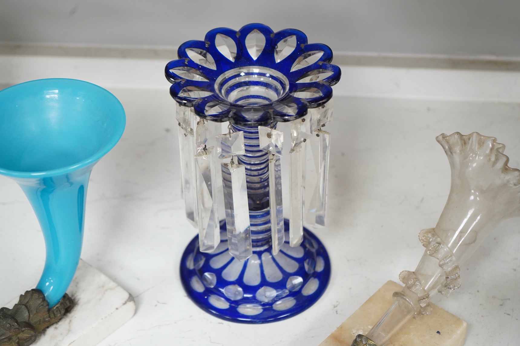 A late 19th century blue overlay glass table lustre and two late 19th century cornucopia shaped glass and brass mounted vases on stands